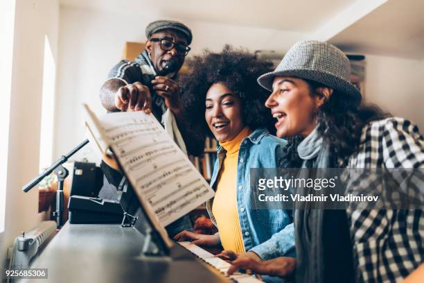 young women singing and playing the piano - singing stock pictures, royalty-free photos & images