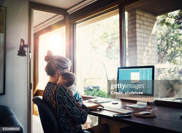 het is niet gemakkelijk, maar ze is aan de taak - werkende moeder stockfoto's en -beelden