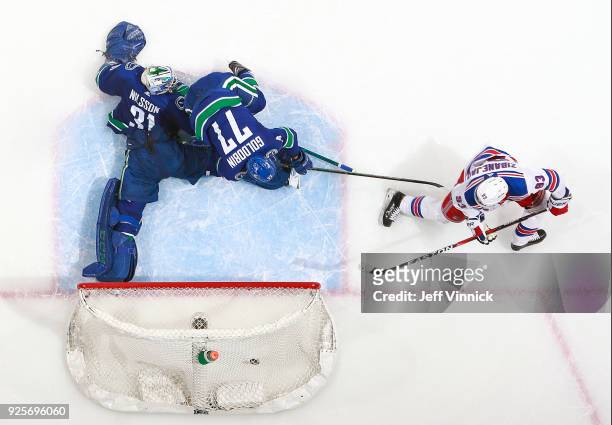 Nikolay Goldobin and Anders Nilsson of the Vancouver Canucks look on as Mika Zibanejad of the New York Rangers scores during their NHL game at Rogers...