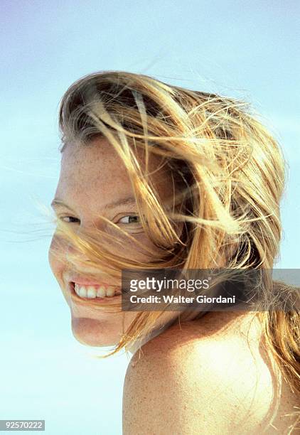 woman smiling with hair blowing in wind - giordani walter stockfoto's en -beelden