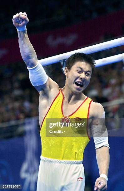 Gold medal winner Li Xiaopeng of China pumps his fist in the air, 25 September 2000, following the men's apparatus finals on the parallel bars at the...