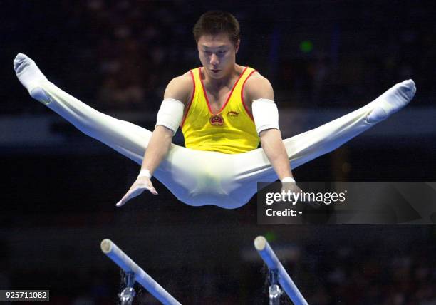 Gold medal winner Li Xiaopeng of China performs on the parallel bars, 25 September 2000, during the men's apparatus finals at the Sydney 2000 Olympic...