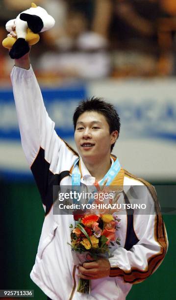 Li Xiaopeng of China celebrates after receiving his medal for the vault event during the men's apparatus finals for the 14th Asian Games in Busan, 05...