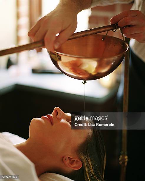 woman getting ayurvedic treatment - shirodhara stock pictures, royalty-free photos & images
