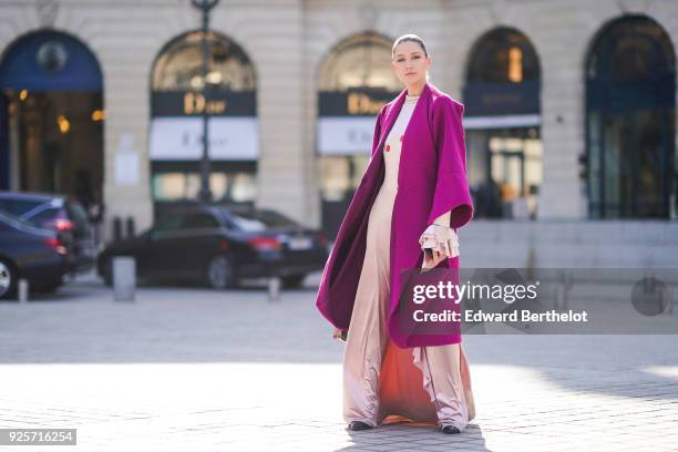 Landiana Cerciu wears a purple coat, a pink slik dress, a Furla bag, during Paris Fashion Week Womenswear Fall/Winter 2018/2019, on February 28, 2018...