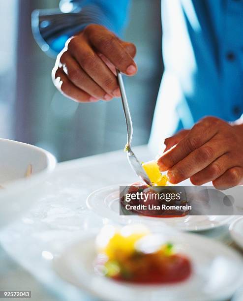 person plating tomato salad - food plating fotografías e imágenes de stock