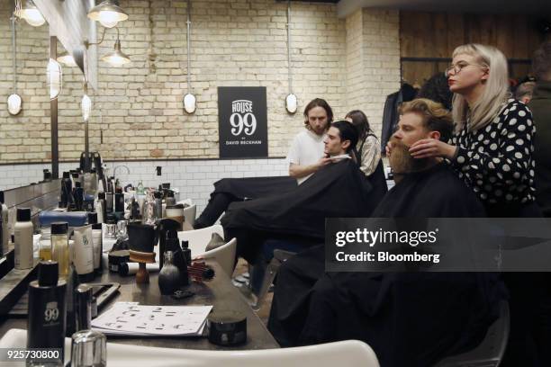 Josh Mario John, model and lifestyle blogger, second right, has his beard groomed during a launch event for House 99, a grooming brand for men...