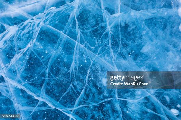 surface of winter ice on baikal lake in siberia . blue background of ice texture - ice stock-fotos und bilder