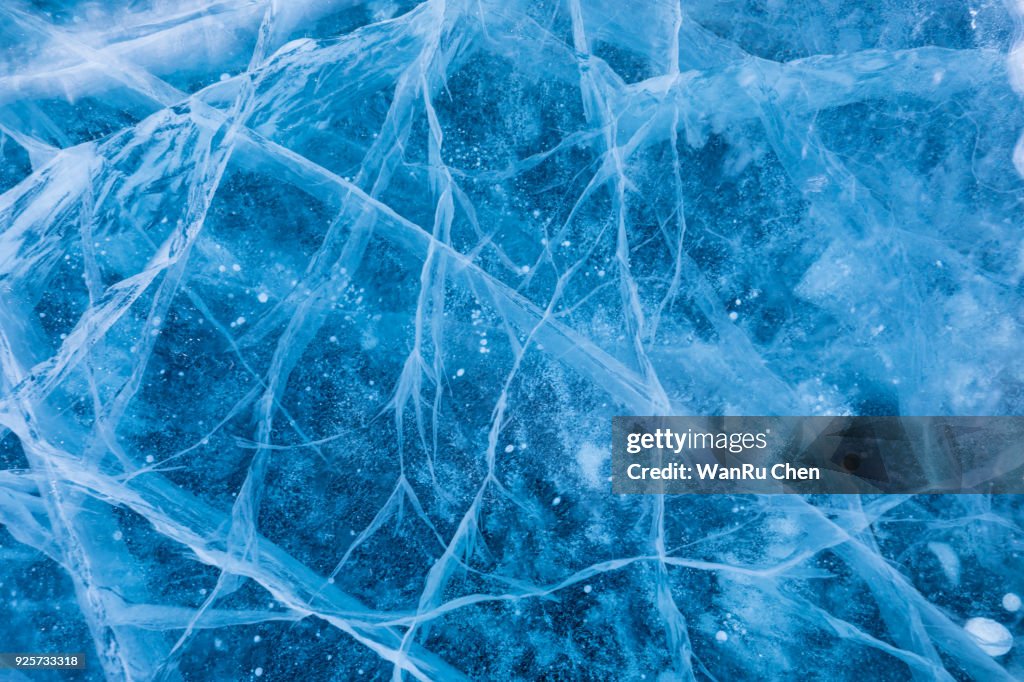 Surface of winter ice on Baikal lake in Siberia . Blue background of Ice texture