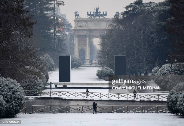 People walk in Sempione garden after snowfall in Milan on March 1, 2018. Fresh heavy snowfalls and icy blizzards were expected to lash Europe on...