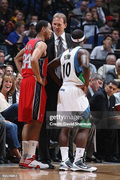 Head coach Kurt Rambis and Jonny Flynn of the Minnesota Timberwolves talk with Devin Harris of the New Jersey Nets during the season opening game on...