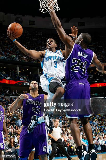 Chris Paul of the New Orleans Hornets shoots over Sean May and Desmond Mason of the Sacramento Kings on October 30, 2009 at the New Orleans Arena in...