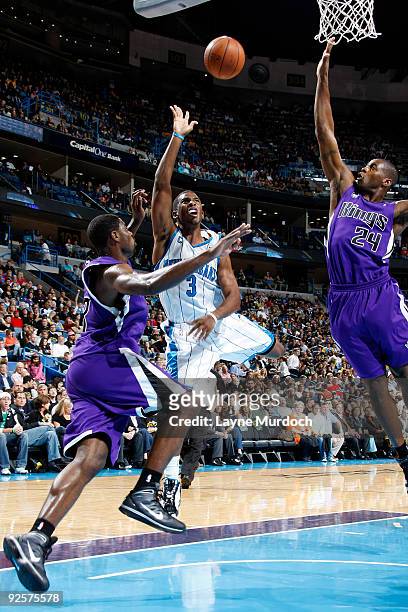 Chris Paul of the New Orleans Hornets shoots between Tyreke Evans and Desmond Mason of the Sacramento Kings on October 30, 2009 at the New Orleans...
