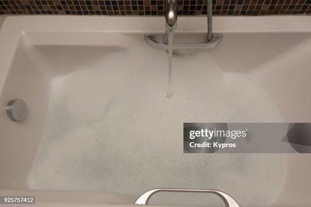 europe, greece, athens, piraeus area, 2018: view of water running into bathtub filled with soapy bubbles - running water bath stock pictures, royalty-free photos & images