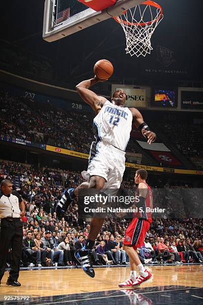 Dwight Howard of the Orlando Magic shoots against Brook Lopez of the New Jersey Nets on October 30, 2009 at the IZOD Center in East Rutherford, New...