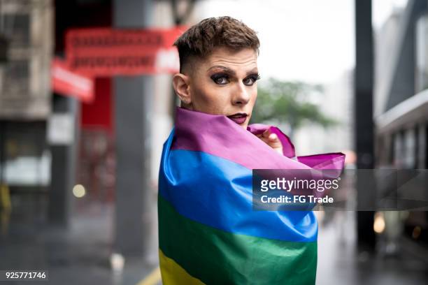 ragazzo gay fiducioso che tiene la bandiera arcobaleno - orgoglio foto e immagini stock