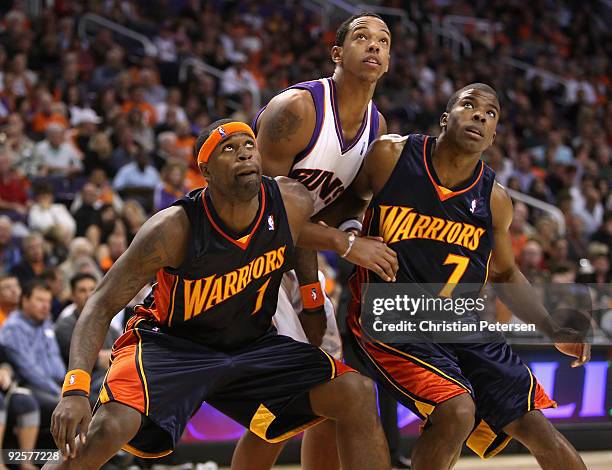 Stephen Jackson and Kelenna Azubuike of the Golden State Warriors block out Channing Frye of the Phoenix Suns during a free throw shot in the NBA...