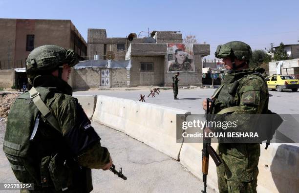 Picture taken on March 1, 2018 shows members of the Russian military police standing guard at the Wafideen checkpoint on the outskirts of Damascus...