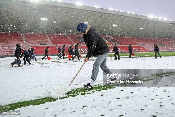 Manager Chris Coleman helps as Sunderland staff clear the pitch to enable first team training at Stadium of Light on March 1, 2018 in Sunderland,...