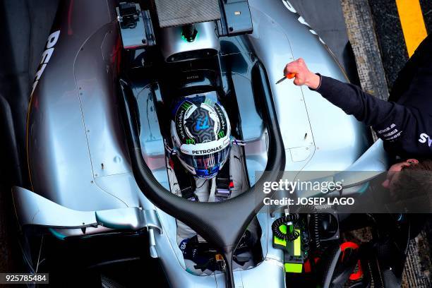 Mercedes' Finnish driver Valtteri Bottas rests in the pits at the Circuit de Catalunya on March 1, 2018 in Montmelo on the outskirts of Barcelona...