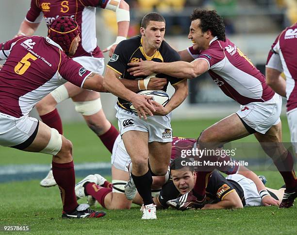 Shaun Treeby of Wellington is tackled by Joe Tuineau and Jason Kawau of Southland during the Air New Zealand Cup Semi Final match between Wellington...