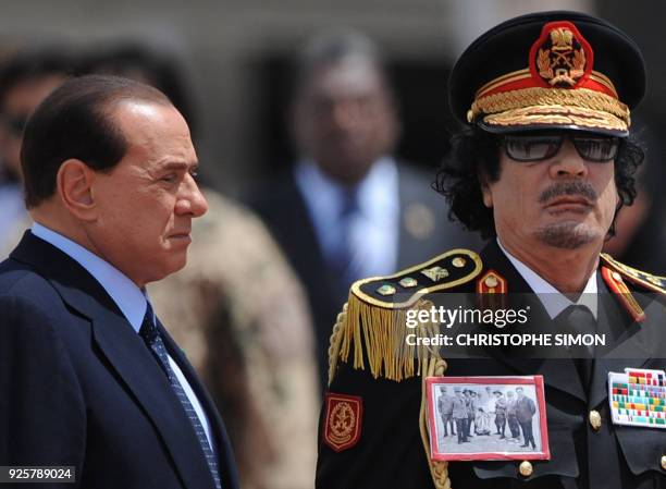 Libya's leader Moamer Kadhafi is greeted by Italian Prime Minister Silvio Berlusconi upon his arrival for his first visit to Italy on June 10, 2009...