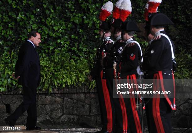 Italian Prime Minister Silvio Berlusconi walks as he waits for the arrival of Kazakhstan president Nursultan Nazarbayev prior their meeting on...