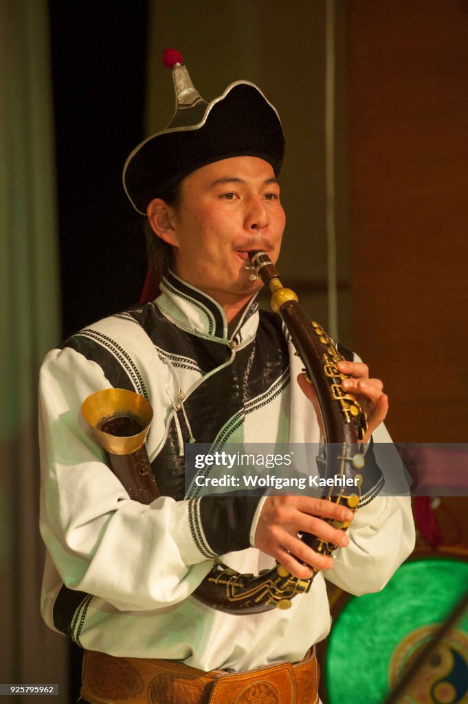 A Mongolian musician is playing the Bishguur, a traditional...