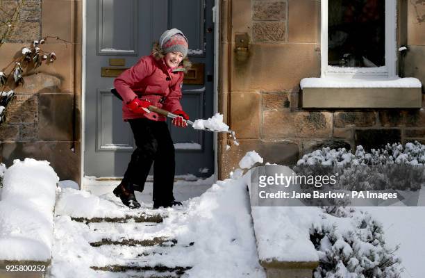 Isla Brown, aged 10, clears snow from outside her house in Holyrood, Edinburgh, as storm Emma, rolling in from the Atlantic, looks poised to meet the...