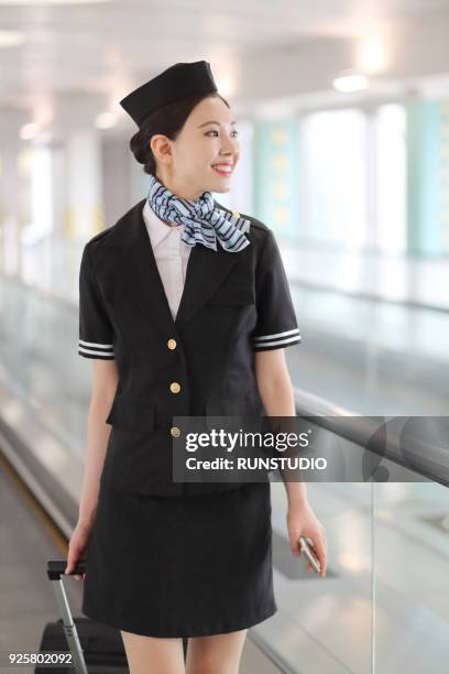 stewardess on moving walkway at airport - 客室乗務員 ストックフォトと画像