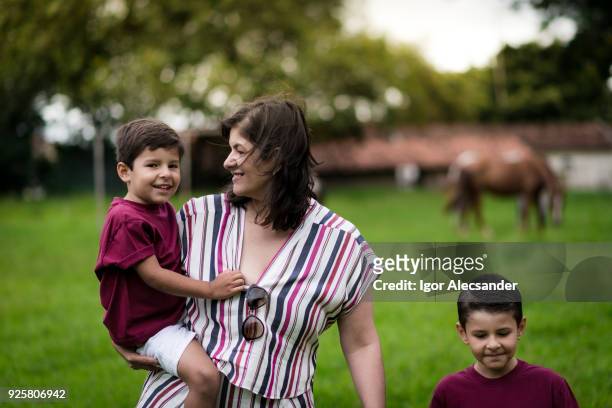mutter und kinder zu fuß in der farm - mom sits on sons lap stock-fotos und bilder