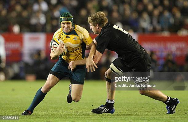 Matt Giteau of the Wallabies is challenged by Adam Thomson of the All Blacks during the 2009 Bledisloe Cup match between the New Zealand All Blacks...