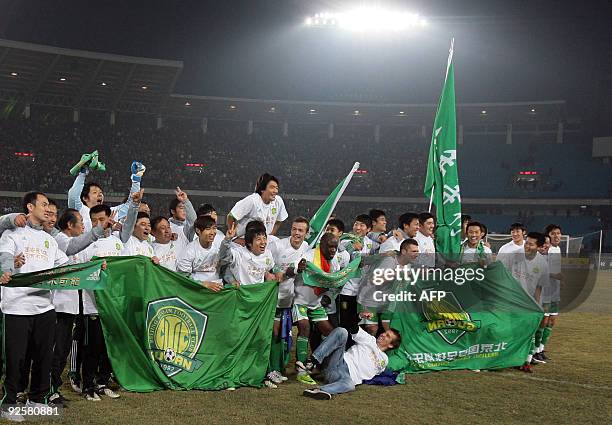 Beijing Guoan players celebrate after winning the Chinese Super League title in Beijing on October 31, 2009. Beijing Guoan football club brought the...