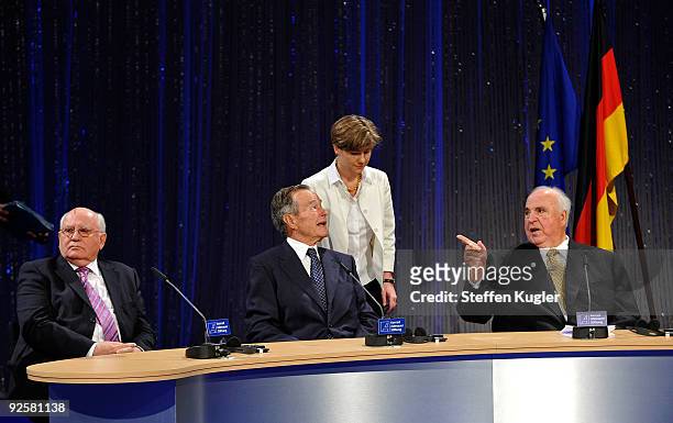 Former German Chancellor Helmut Kohl gestures towards former US President George H. W. Bush while Kohls wife, Maike Richter-Kohl and former Soviet...