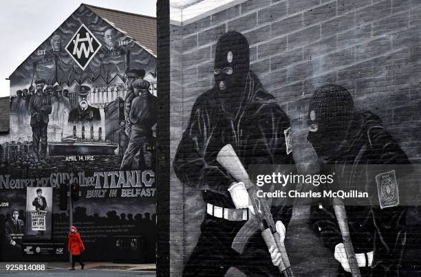 Woman crosses the street against the backdrop of the John Stewart painted mural dedicated to the men, women and children who lost their lives on the...