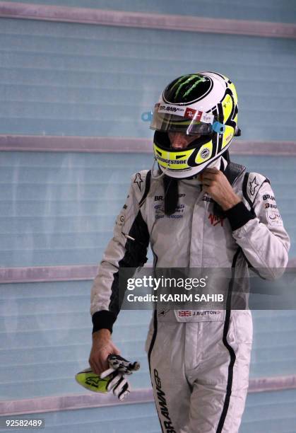 Brawn GP's British driver Jenson Button walks in the parc ferme of the Yas Marina Circuit on October 31, 2009 in Abu Dhabi, after the qualifying...