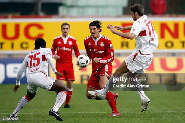 Mario Gomez of Muenchen is challenged by Arthur Boka and Matthieu Delpierre of Stuttgart during the Bundesliga match between VfB Stuttgart and Bayern...