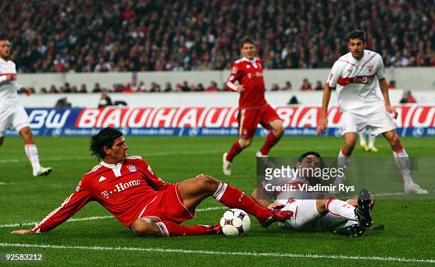 Mario Gomez of Bayern and Serdar Tasci of Stuttgart slide in for the ball during the Bundesliga match between VfB Stuttgart and FC Bayern Muenchen at...