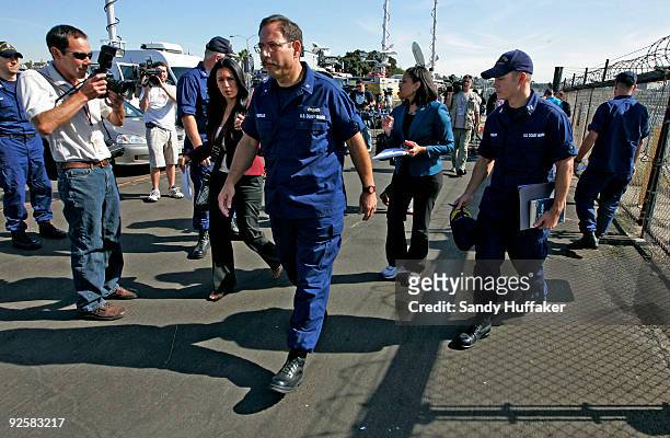 Coast Guard Rear Admiral Joseph Castillo walks away after speaking to the media about a collision between a Marine Corps AH-1W Super Cobra helicopter...