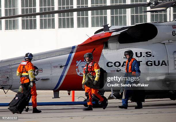 Coast Guard personnel depart on a search and rescue mission after a collision between a Marine Corps AH-1W Super Cobra helicopter and a Coast Guard...