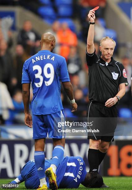 Didier Drogba of Chelsea lays on the ground as referee Peter Walton shows a red card to Boltons Jlloyd Samuel during the Barclays Premier League...