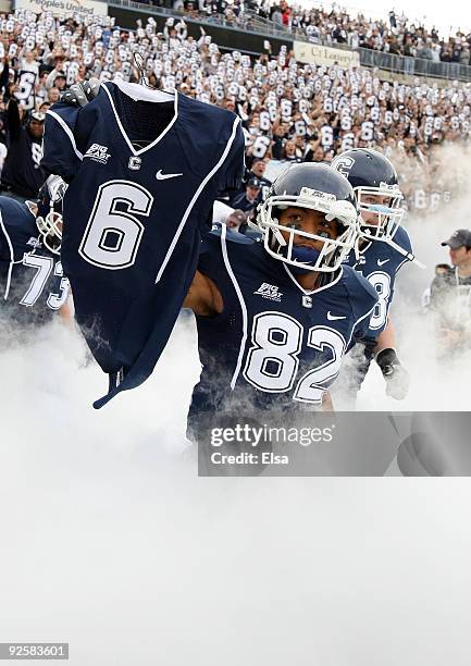 Kashif Moore of the Connecticut Huskies carries out the jersey of murdered teammate Jasper Howard before the game against the Rutgers Scarlet Knights...