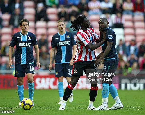 Kenwyne Jones of Sunderland pushes Herita Ulunga of West Ham United in the face and gets a red Card during the Barclays Premier League match between...