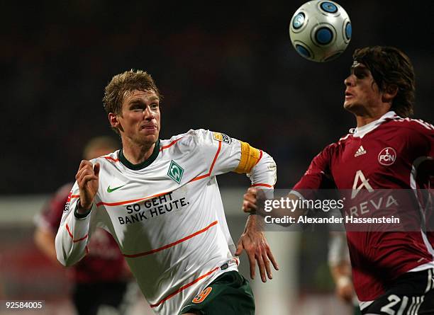 Dario Vidosic of Nuernberg battles for the ball with Per Mertesacker of Bremen during the Bundesliga match bewteen 1.FC Nuernberg and Werder Bremen...