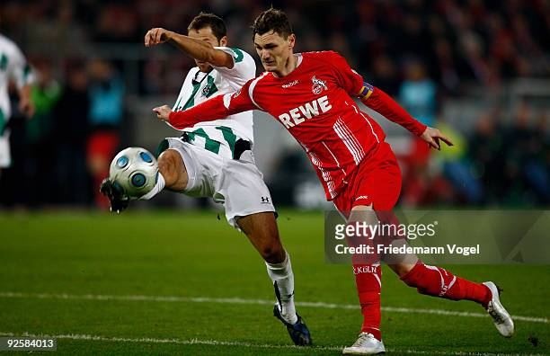 Milivoje Novakovic of Koeln in action with Steven Cherundolo of Hannover during the Bundesliga match between 1. FC Koeln and Hannover 96 at the Rhein...
