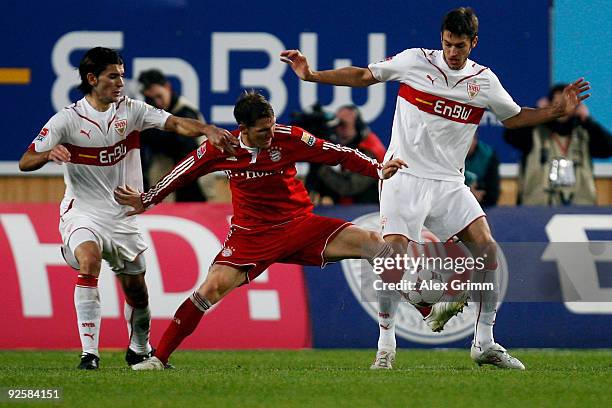 Bastian Schweinsteiger of Muenchen is challenged by Serdar Tasci and Matthieu Delpierre of Stuttgart during the Bundesliga match between VfB...