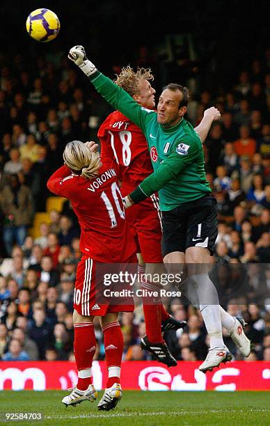 Mark Schwarzer of Fulham punches clear from Dirk Kuyt and Andriy Voronin of Liverpool during the Barclays Premier League match between Fulham and...