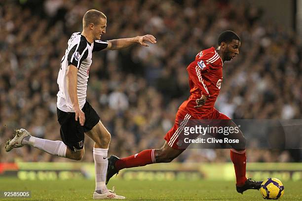 Ryan Babel of Liverpool is challenged by Brede Hangeland of Fulham during the Barclays Premier League match between Fulham and Liverpool at Craven...