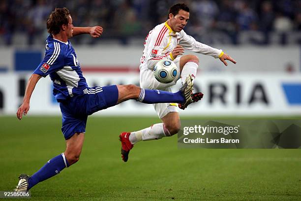 Benedikt Hoewedes of Schalke challenges Gonzalo Castro of Leverkusen during the Bundesliga match between FC Schalke 04 and Bayer 04 Leverkusen at the...