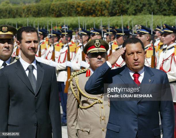 Syrian President Bashar al-Assad and his Venezuelan counterpart Hugo Chavez review an honour guard at Al-Shaab Palace in Damascus, 30 August 2006....